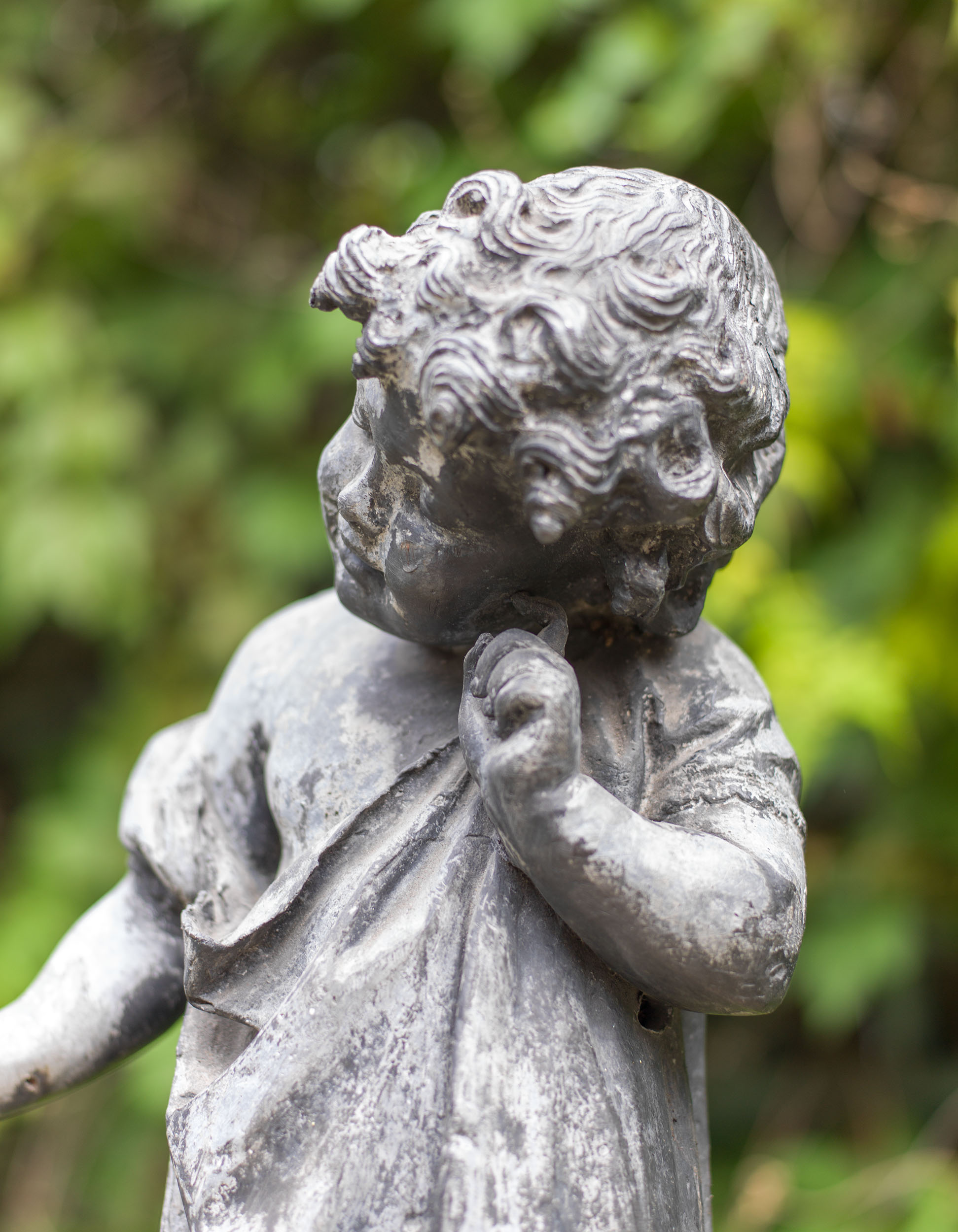 A lead garden figure of a listening child