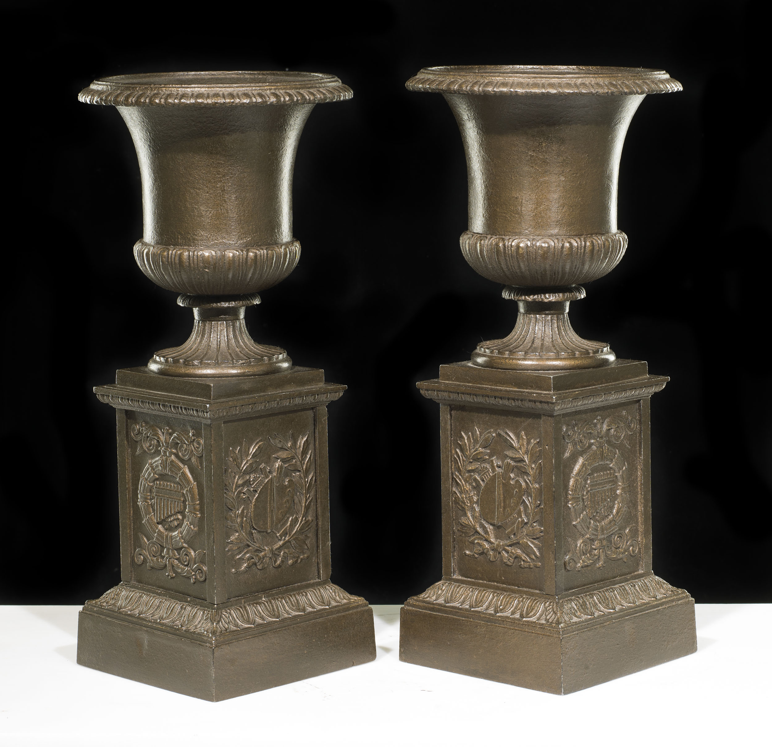 A Small Pair of Cast Iron Urns & Plinths