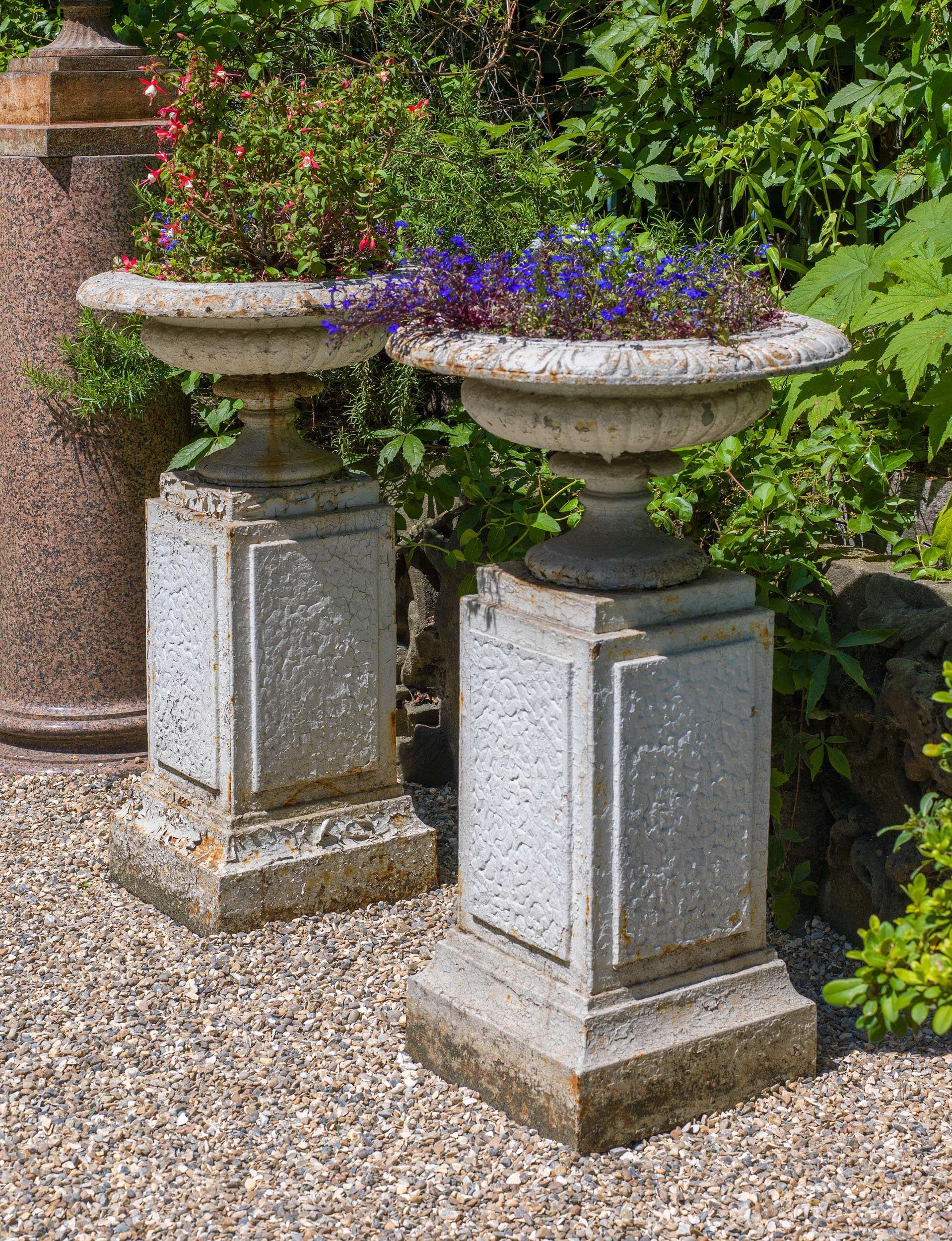 A Pair of Cast Iron Garden Urns on Plinths