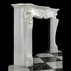 Antique Rococo Louis XV Cheminee in White Marble 
Delightful Louis XV Rococo Cheminee in white Statuary Marble with delicate, fine carving. A richly floral Cartouche centres the contoured frieze and serpentine shelf, complimented by flanking high relief capitals and scrolled, angled cabriole jambs. 19th century French.

