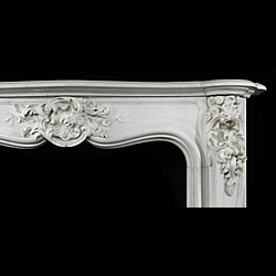 Antique Rococo Louis XV Cheminee in White Marble 
Delightful Louis XV Rococo Cheminee in white Statuary Marble with delicate, fine carving. A richly floral Cartouche centres the contoured frieze and serpentine shelf, complimented by flanking high relief capitals and scrolled, angled cabriole jambs. 19th century French.

