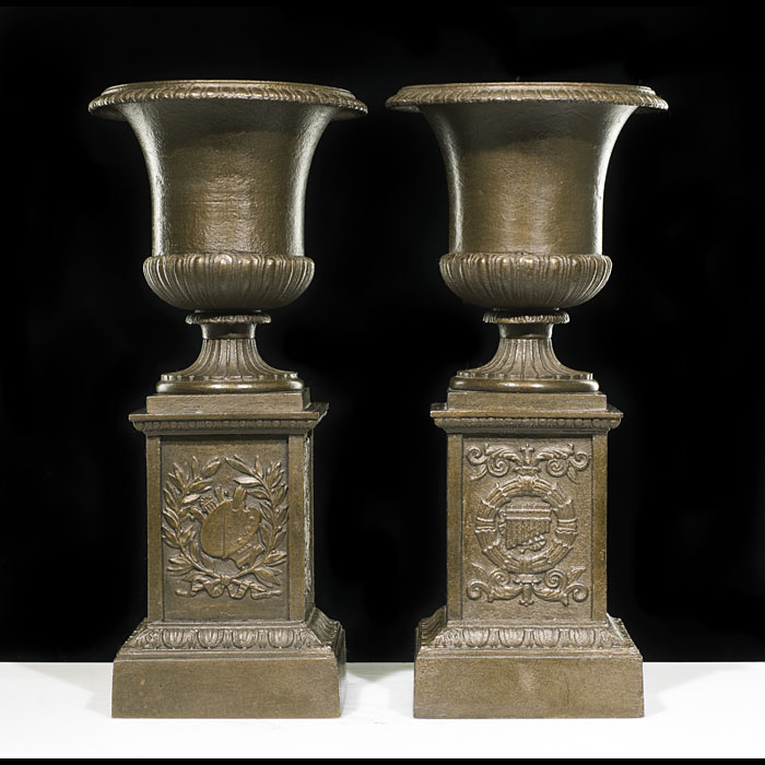 A Small Pair of Cast Iron Urns & Plinths