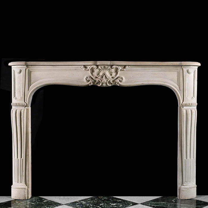 An antique Rococo style limestone fireplace surround in the Louis XV manner 