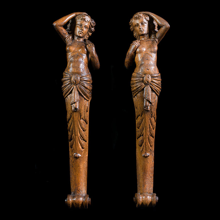A pair of carved oak female caryatids
