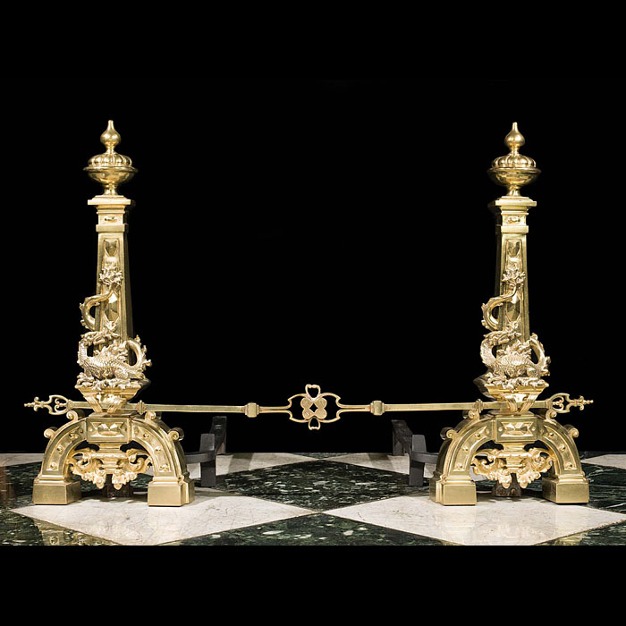 An antique pair of brass dragon andirons and fender bar 