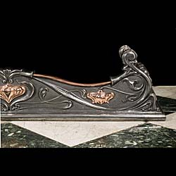 An Antique Art Nouveau cast copper fireplace fender