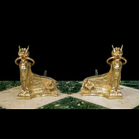 Antique pair of Egyptian style brass firedog andirons.