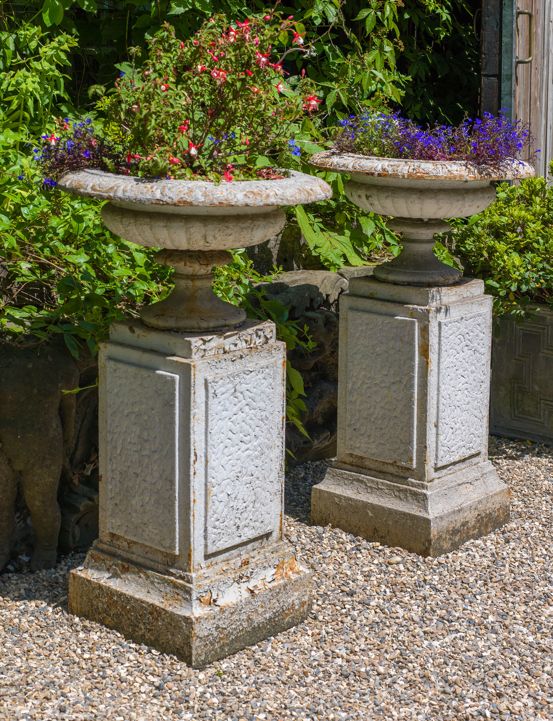 A Pair of Cast Iron Garden Urns on Plinths