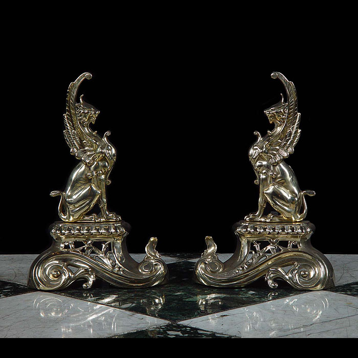  A pair of antique brass Rococo style griffin fire dogs   