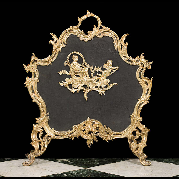 A Rococo style brass and mesh fire guard