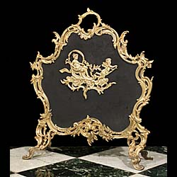 A Rococo style brass and mesh fire guard