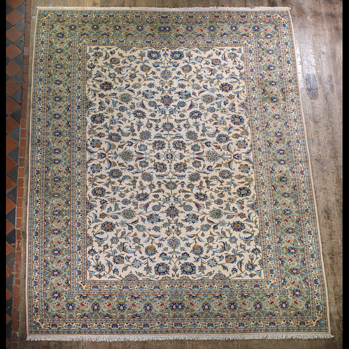 A large ivory, blue & magenta Kashan carpet