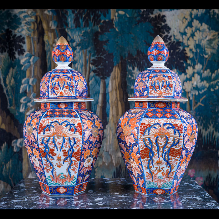 A pair of hand-painted hexagonal Meiji period Imari lidded vases